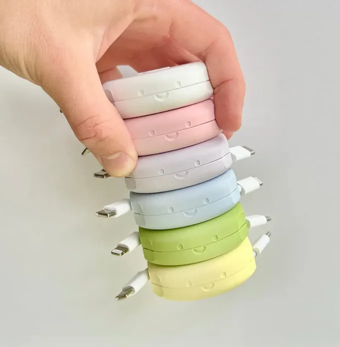 Pebbl case study · stack of pastel-coloured 3D-printed retractable cable winders held in hand