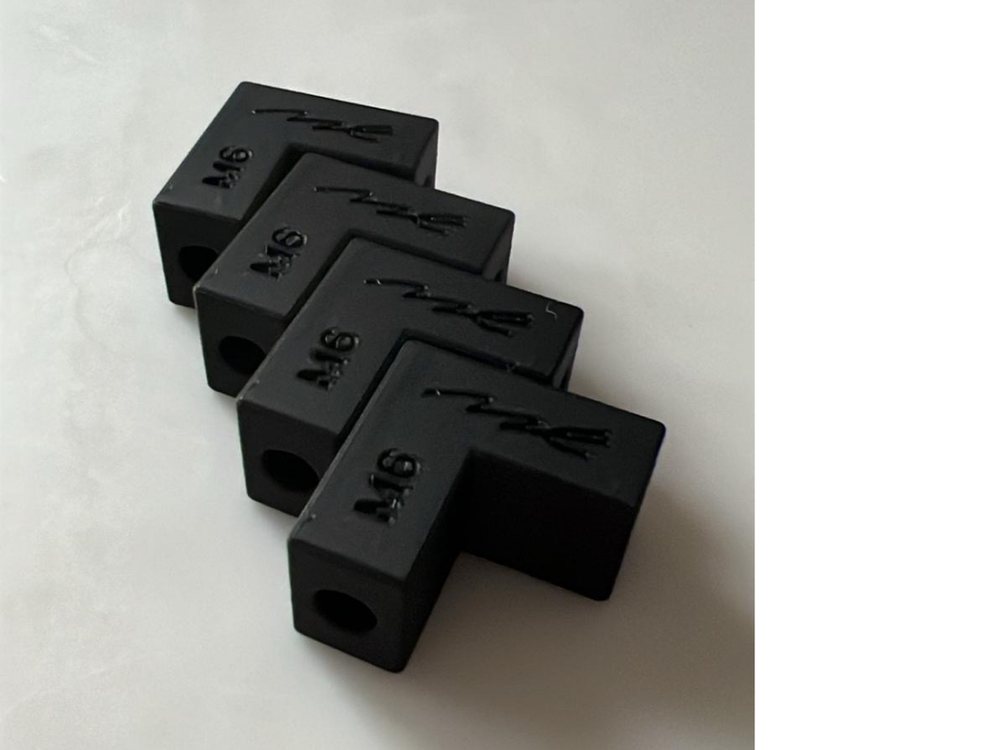 A batch of identical 3D-printed black blocks, each stamped with the same serial mark · real serialised production parts